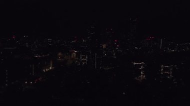 Manchester, İngiltere 'nin gece hava aracı görüntüleri. Gece gökdelenleri şehrin ışıklarında duruyor..