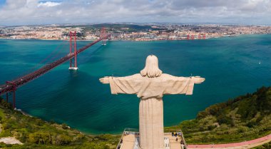Kral İsa 'nın Sığınağı, Santuario de Cristo Rei' nin hava görüşü. Lizbon, Portekiz. Arkaplanda 25 de Abril Köprüsü ile gün doğumunda drone fotoğrafı