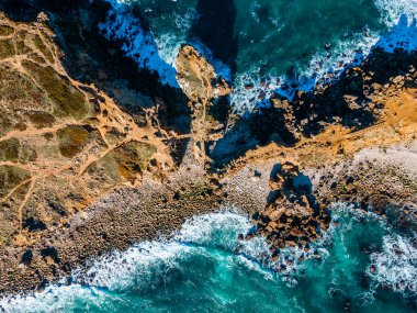 Azure temiz su mercan plajının kayalık sahilleri vurur. Havadan üst görünüm