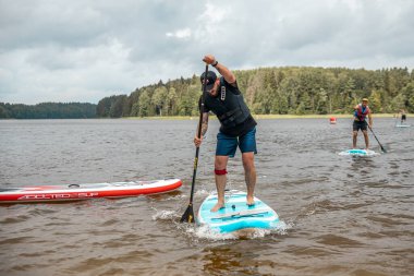 Vaidava, Latvia - 01.08.2021: SUP stand up paddle boarding. SUP competition, race. awesome active outdoor recreation. 