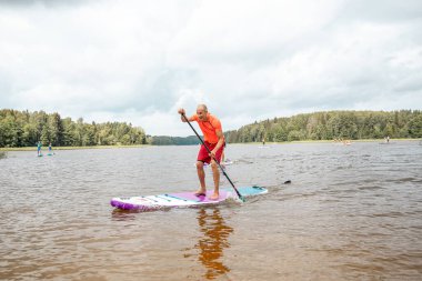 Vaidava, Latvia - 01.08.2021: SUP stand up paddle boarding. SUP competition, race. awesome active outdoor recreation. 