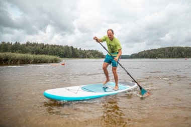 Vaidava, Latvia - 01.08.2021: SUP stand up paddle boarding. SUP competition, race. awesome active outdoor recreation. 