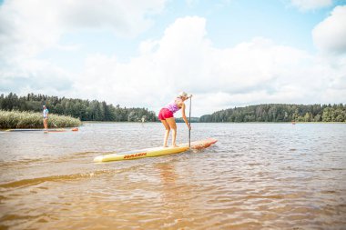 Vaidava, Latvia - 01.08.2021: SUP stand up paddle boarding. SUP competition, race. awesome active outdoor recreation. 