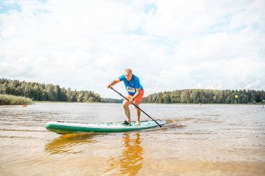 Vaidava, Latvia - 01.08.2021: SUP stand up paddle boarding. SUP competition, race. awesome active outdoor recreation. 