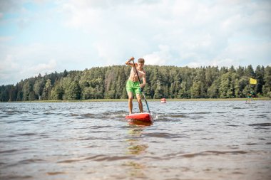 Vaidava, Latvia - 01.08.2021: SUP stand up paddle boarding. SUP competition, race. awesome active outdoor recreation. 