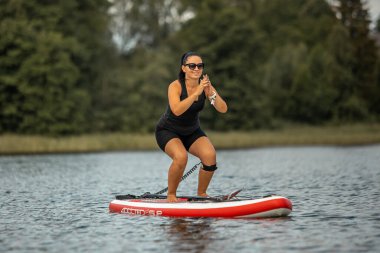 Vaidava, Letonya - 01.08.2021: Yoga un SUP ayağa kalk. muhteşem aktif açık hava eğlencesi. 