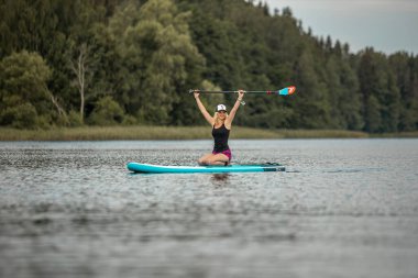 Vaidava, Latvia - 01.08.2021: Yoga un SUP stand up paddle board. awesome active outdoor recreation. 