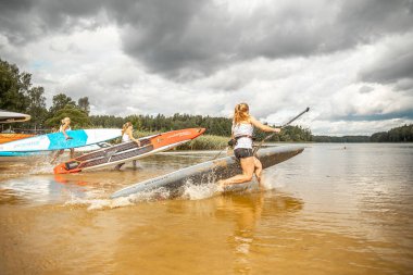 Vaidava, Letonya - 01.08.2021: Birçok insan SUP ile kürek çekiyor. SUP yarışması, yarış. muhteşem aktif açık hava eğlencesi.