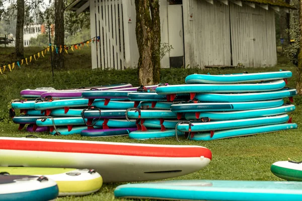 Multicolored SUP boards. Station for active recreation and water sports, inflatable boards