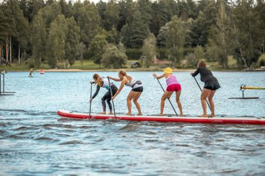 Vaidava, Latvia - 01.08.2021: A lot of People paddle with SUP stand up paddle board. SUP competition, race. awesome active outdoor recreation.