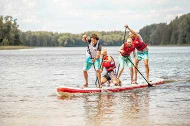 Vaidava, Latvia - 01.08.2021: A lot of People paddle with SUP stand up paddle board. SUP competition, race. awesome active outdoor recreation.