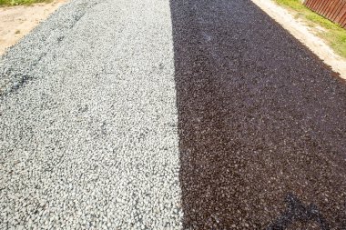 Yeni çakıl yolu. Yolun yarısında sıvı asfalt, bir kova reçineden erimiş zift dökülür..