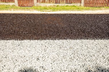 Yeni çakıl yolu. Yolun yarısında sıvı asfalt, bir kova reçineden erimiş zift dökülür..