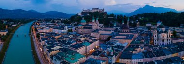 Avusturya 'nın Salzburg şehrinin gece boyunca güzel bir hava aracı panoraması. Yazın tarihi Salzburg ve Salzach nehrinin manzarası.