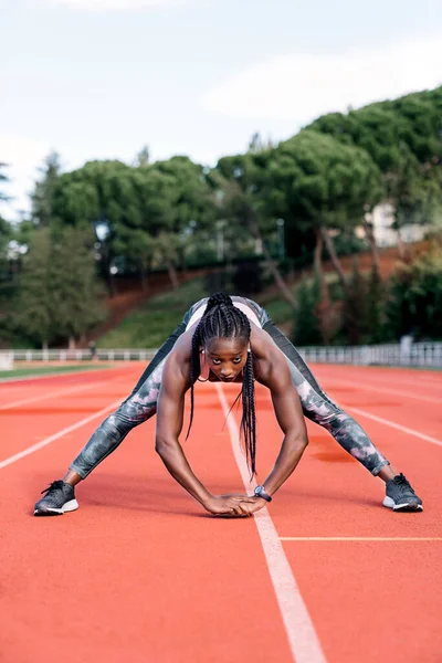 Atleta velocista esticando as pernas — Fotografia de Stock