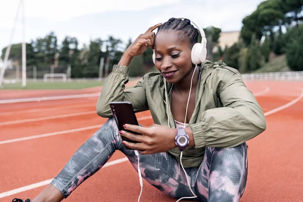 Atleta sprinter sentado escuchando música — Foto de Stock