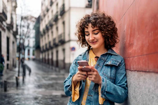 Jovem mulher usando telefone na rua — Fotografia de Stock