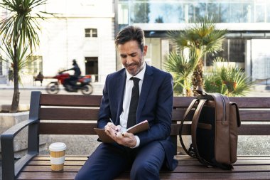 İş adamı şehirde not defterine not alıyor