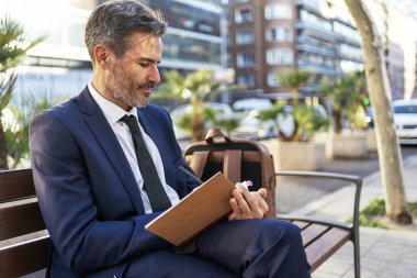 İş adamı şehirde not defterine not alıyor