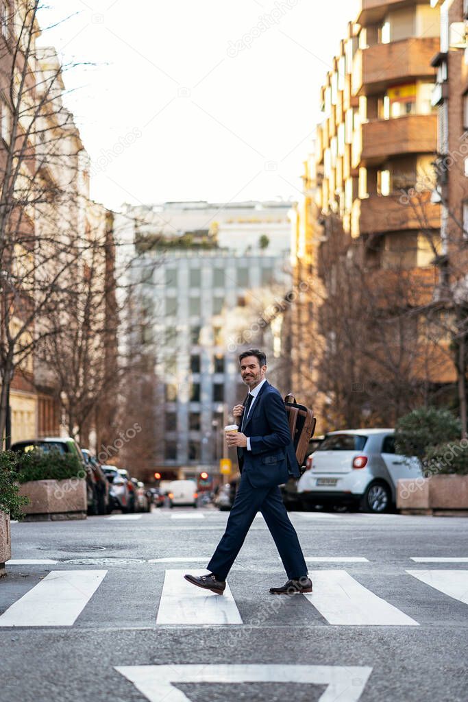 Businessman crossing road in city