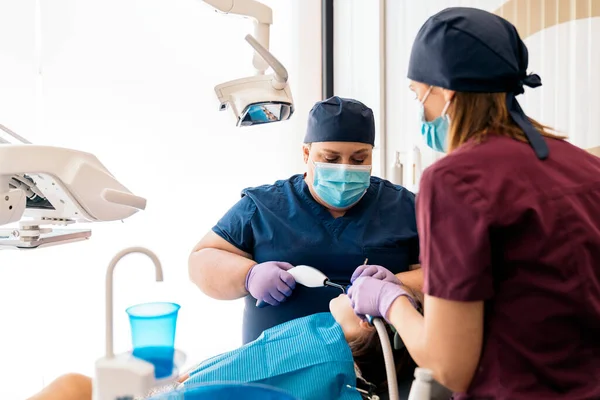 Работники стоматологической клиники с молодым пациентом — стоковое фото