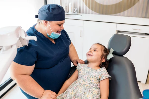 Tandvårdspersonal och liten flicka ler — Stockfoto