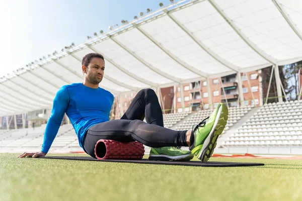 Atleta negro estiramiento en pista deportiva — Foto de Stock