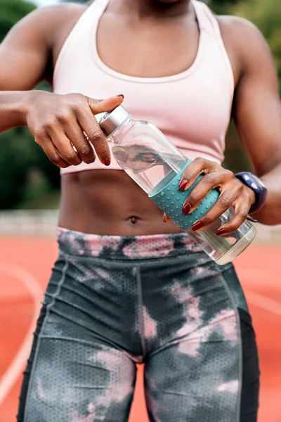 Atleta sprinter abrir una botella de agua — Foto de Stock