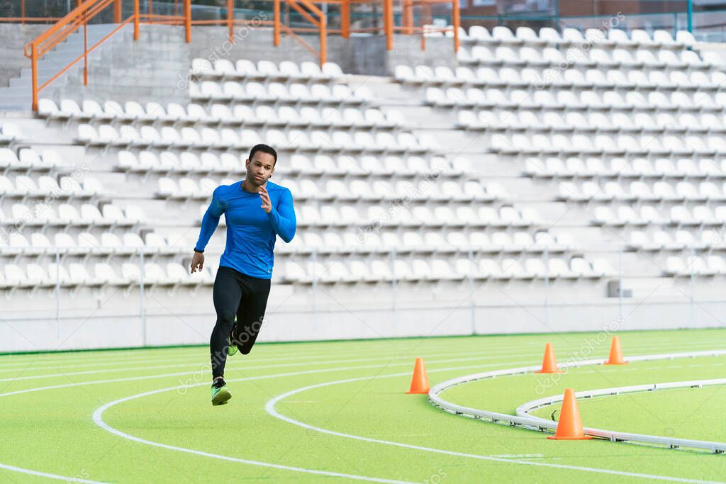 Black man running on a track.