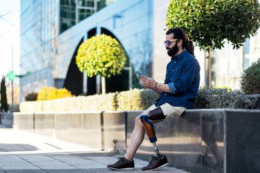 Sokakta bacak sörfü yapan akıllı telefondan anlayan bir adam.