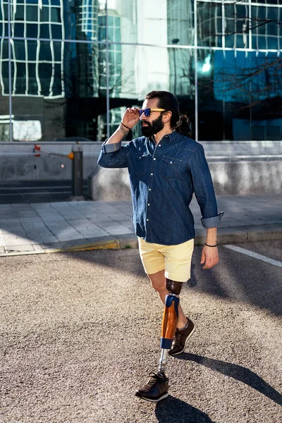 Hombre con estilo con prótesis de pierna cruzando la carretera — Foto de Stock