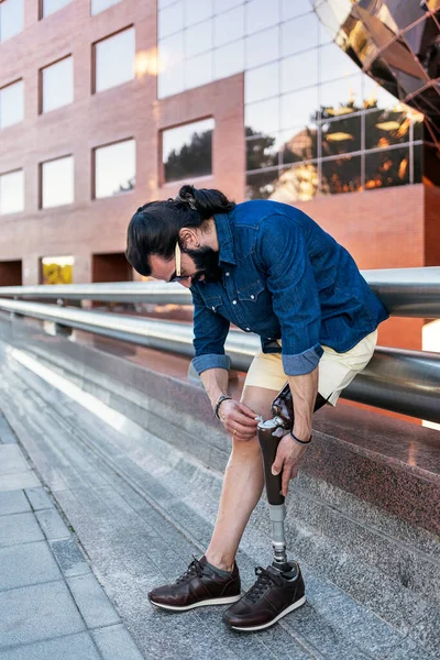 Hombre con prótesis de pierna en calle de ciudad — Foto de Stock