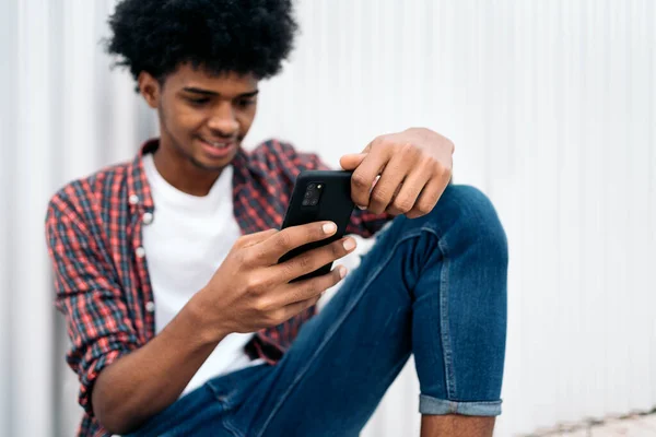 Jovem afro menino usando telefone — Fotografia de Stock