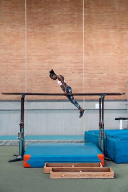Paralel çubuklarda antrenman yapan bir atlet