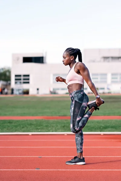 Athlète sprinteuse étirant ses jambes — Photo