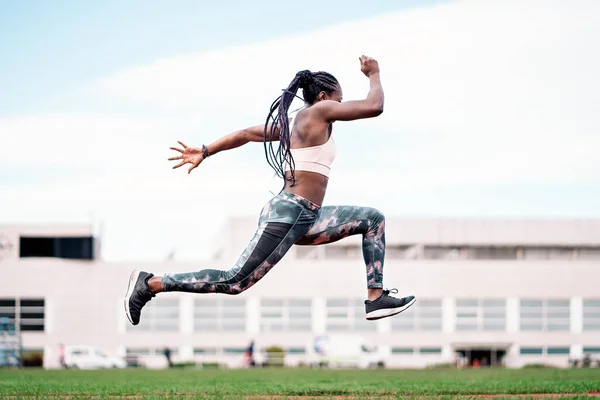 Young African-American athlete sprinter jumping — ストック写真