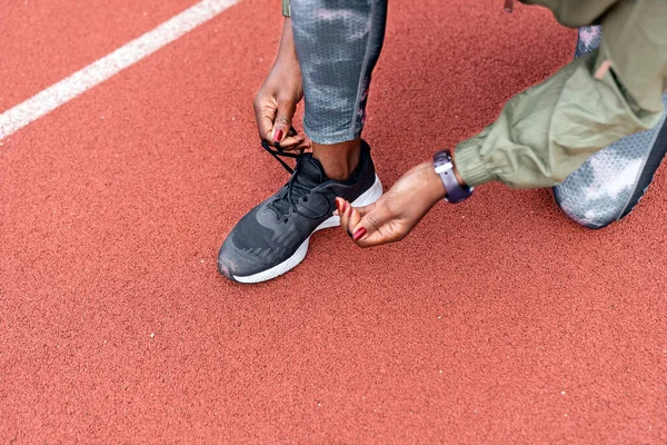 Athlete sprinter tying her shoes — Fotografia de Stock