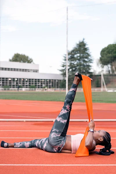 Athlète sprinteuse étirant ses jambes — Photo