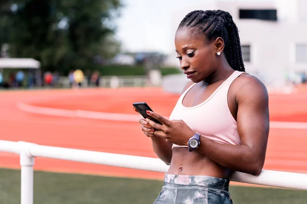 Atleta sprinter compatible con el uso de teléfono móvil — Foto de Stock