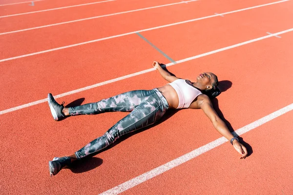 Young athlete sprinter lying down — Fotografia de Stock
