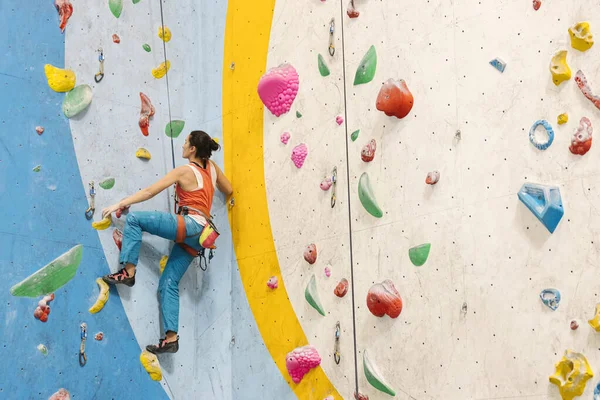 Young Woman rock climbing indoors. — Fotografia de Stock