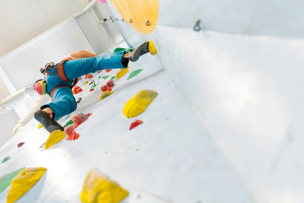 Young Woman rock climbing indoors. — Fotografia de Stock