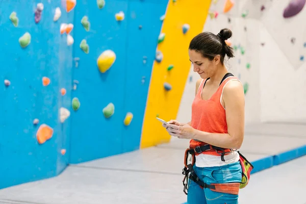 Rock climber woman looking at smartphone. — стоковое фото