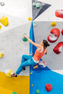 Genç kadın kaya tırmanışı yapıyor..