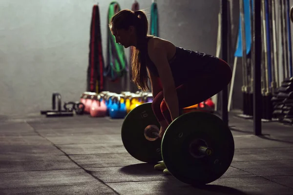 Caucasian woman lifting a barbell. — Foto de Stock