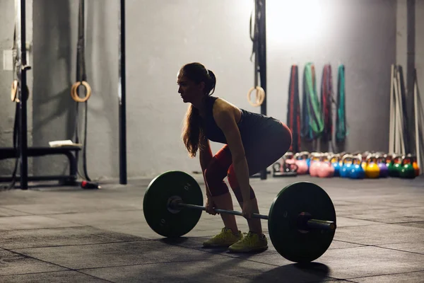 Caucasian woman lifting a barbell. — Foto de Stock