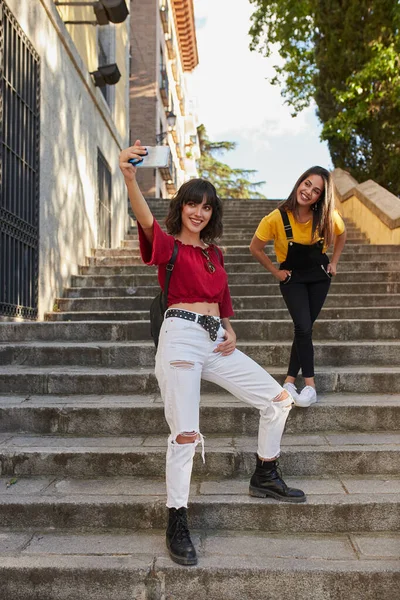 Two teenager girls taking selfie on stairs. — Zdjęcie stockowe