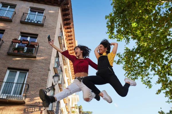 Two teenager girls jumping and taking selfie. — Zdjęcie stockowe