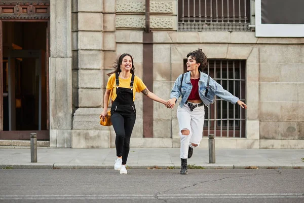 Two teenager girls running down street. — Zdjęcie stockowe