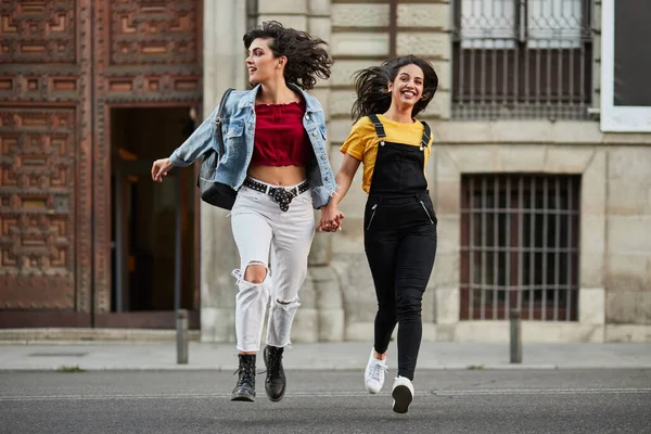 Two teenager girls running down street. — Zdjęcie stockowe